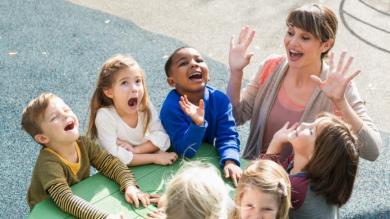 
		Erzieherin und Kinder spielen im Freien
	